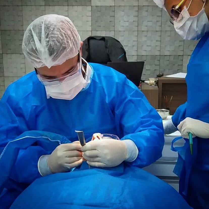 Dr. Betioli e assistência fazendo uma cirurgia de implante dentário